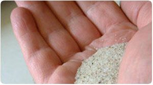 Photo of Silica Sand held in a hand. Silica Sand is used for glass making, silica sand for foundry, golf courses, oil and gas industry